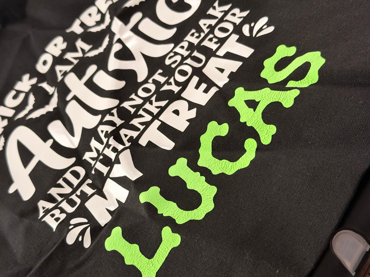 Actual product close-up showing white vinyl wording and green personalised name